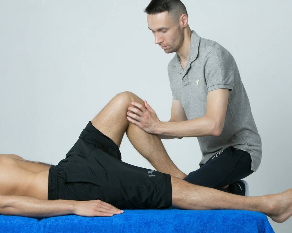 Fysiotherapeut behandelt de knie van een patiënt
